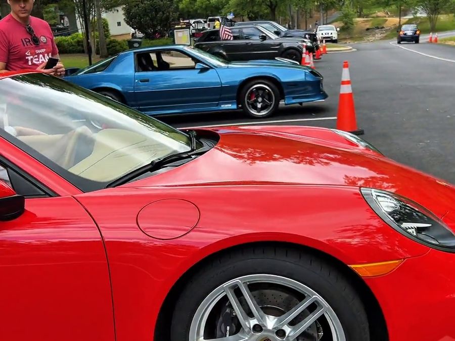 A red sports car and a classic car at the festival's exotic car show